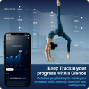 Woman doing a handstand workout with fitness tracking app on smartphone, showing body fat percentage and weight changes over time with progress graphs and analytics.